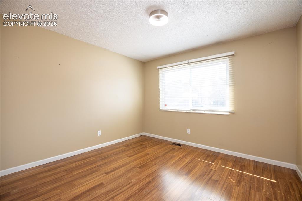 Image 16 of 26: Wood-finish flooring, neutral wall paint, and a white ceiling