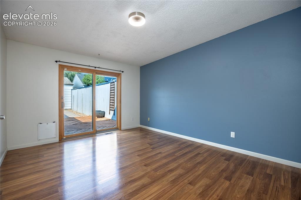Image 19 of 26: Wood-finish flooring, two-tone wall paint, and a sliding glass door with wo