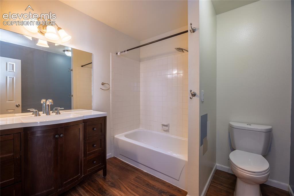 Image 22 of 26: Dark wood-finish vanity with an integrated white sink, chrome fixtures, and