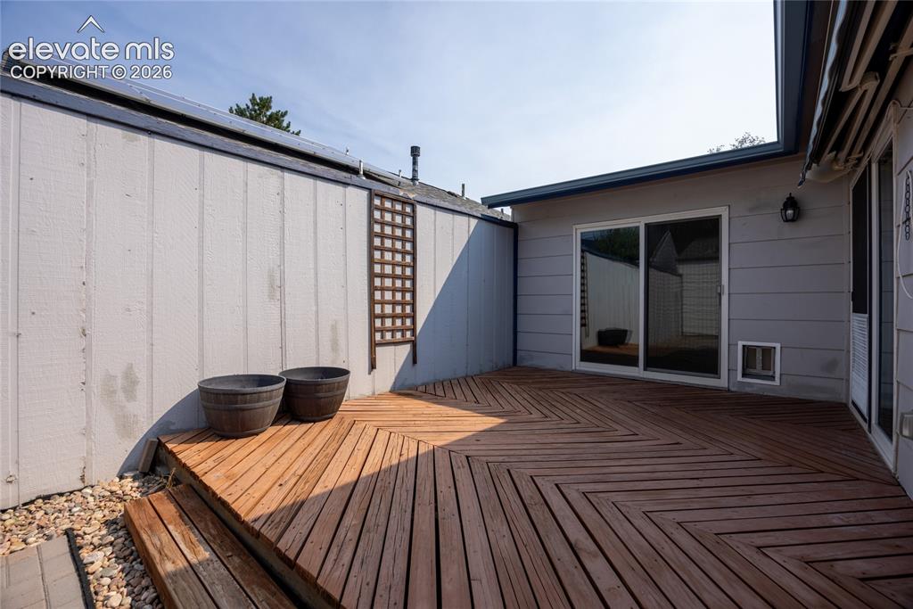 Image 23 of 26: Wood-finish deck with a chevron pattern and steps