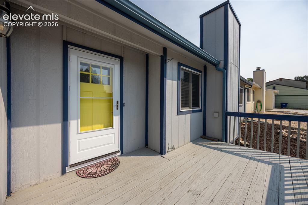 Image 4 of 26: Exterior entry featuring a full-light storm door and painted wood siding