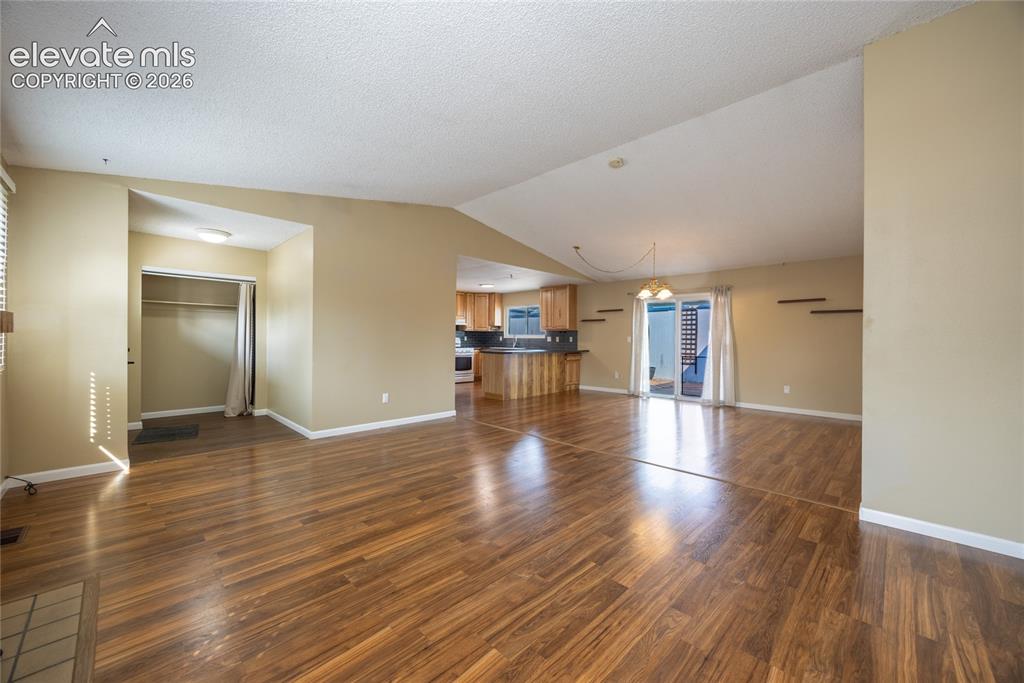 Image 6 of 26: Vaulted ceilings complement wood-finish flooring throughout