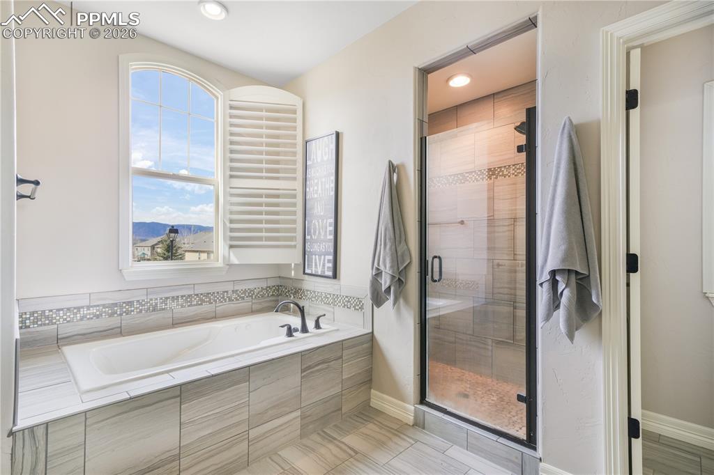 Image 27 of 50: Upper level primary bedroom with sitting area, 5 piece bath with dual vanit