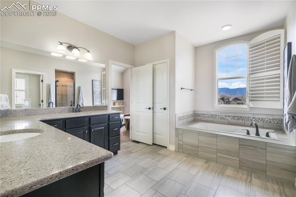 Image 29 of 50: Upper level primary 5  piece bath with dual vanities, large shower and larg