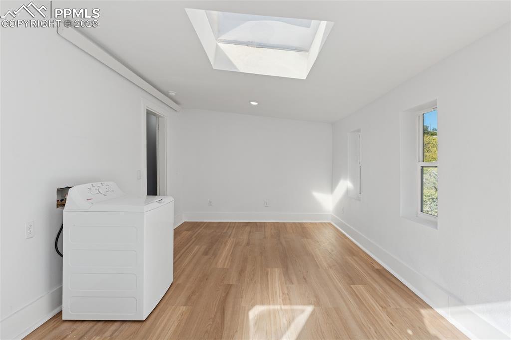 Image 38 of 49: 2nd-floor flat sunroom, laundry, door to backyard
