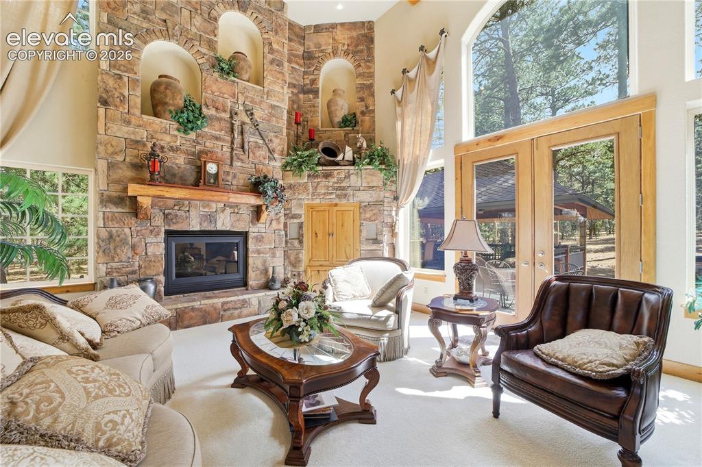 Image 18 of 50: Great Room has stone fireplace, rustic wood mantle, 3 decorative coves