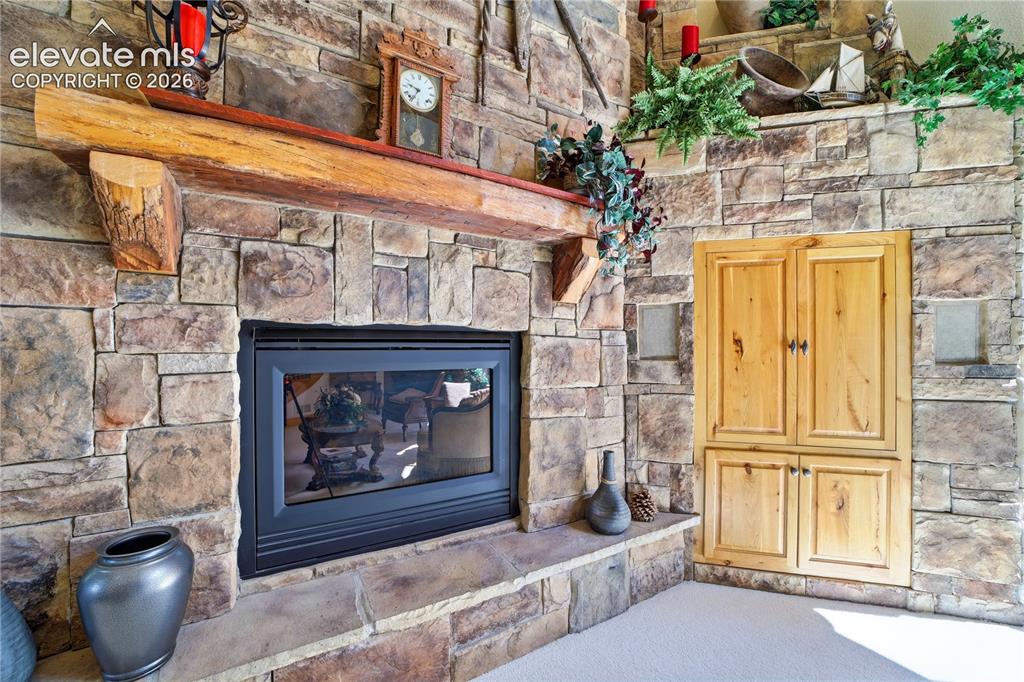 Image 19 of 50: Impressive stone fireplace, rustic mantle, built in entertainment center