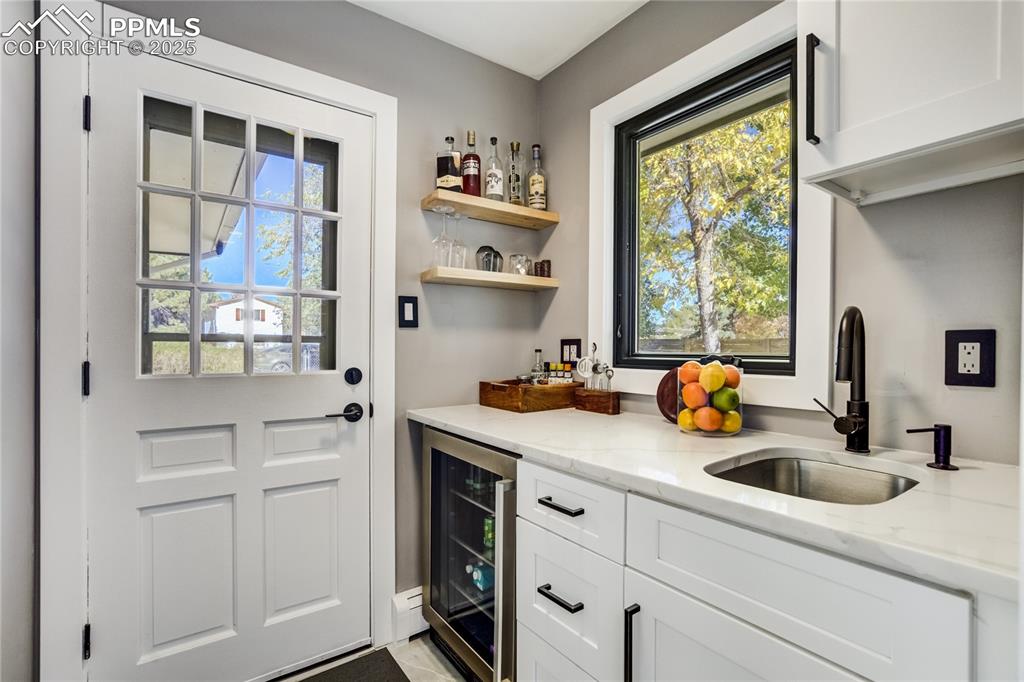 Image 21 of 46: Mudroom with mini-fridge and work sink