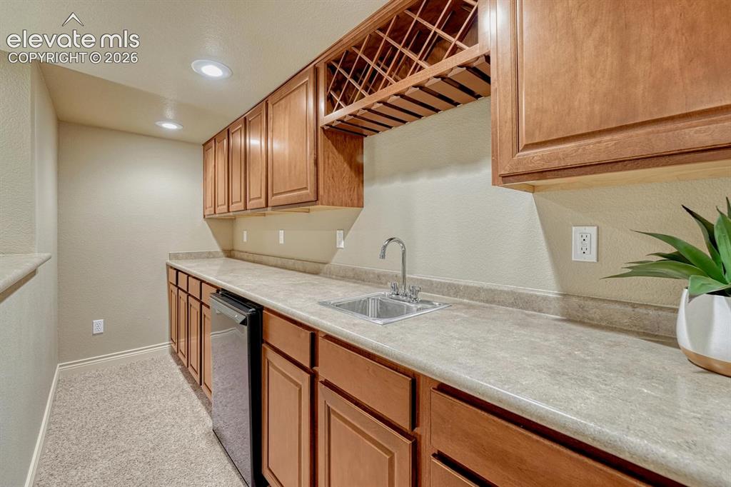 Image 12 of 50: Basement wet bar with refrigerator & built-in wine rack to serve your favor