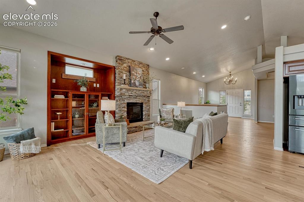 Image 21 of 50: The spacious Great Room features wood flooring, a ceiling fan, custom built