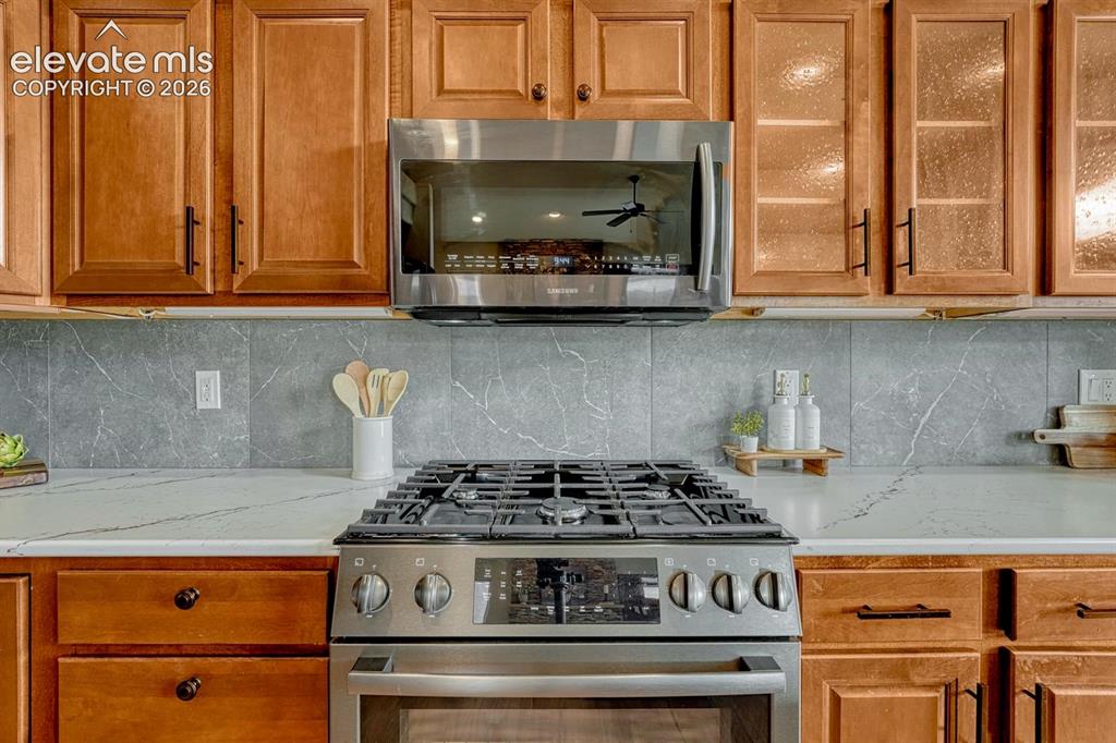 Image 24 of 50: The Kitchen offers a Bosch gas range oven and built-in microwave oven.