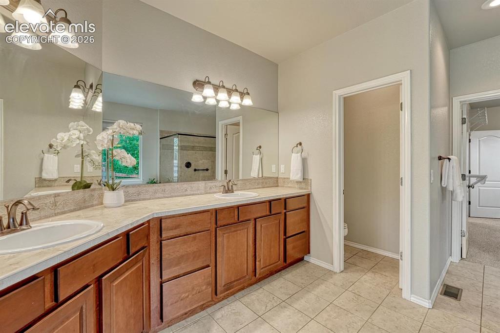 Image 29 of 50: The Primary Bathroom features tile flooring, an expanded dual sink vanity,