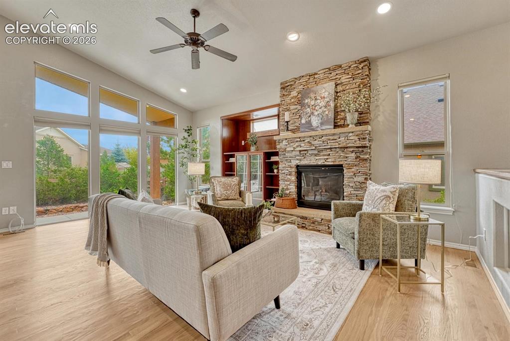 Image 3 of 50: Vaulted Great Room located off the Kitchen with wood floor, wall of windows
