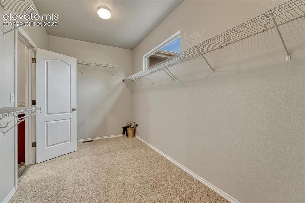 Image 30 of 50: Primary Bedroom walk-in closet with direct access to the Laundry Room.