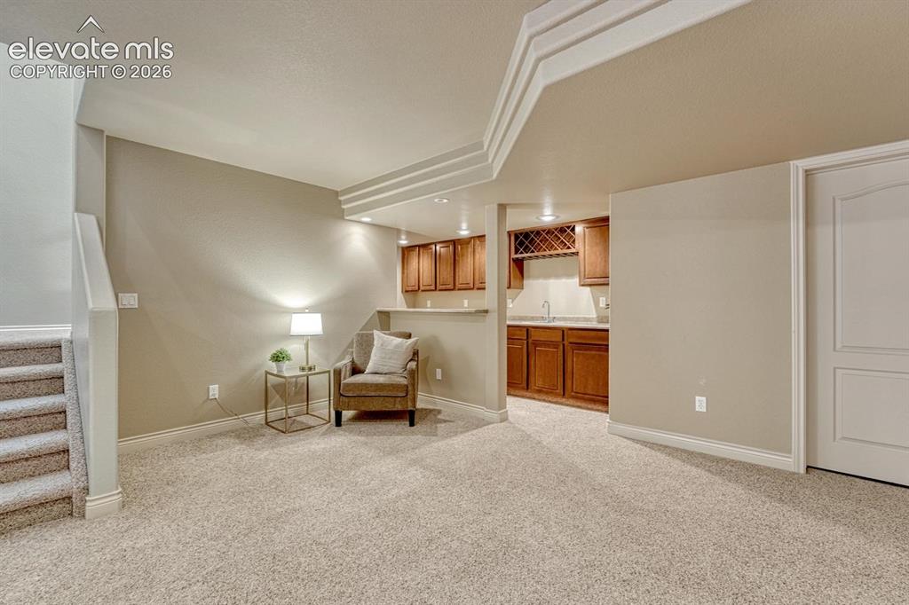 Image 34 of 50: Wet Bar in the Basement Family Room that features upper and lower cabinetry
