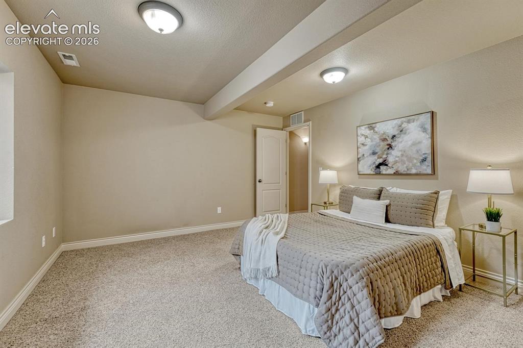 Image 40 of 50: Basement Bedroom #3 with neutral carpet.