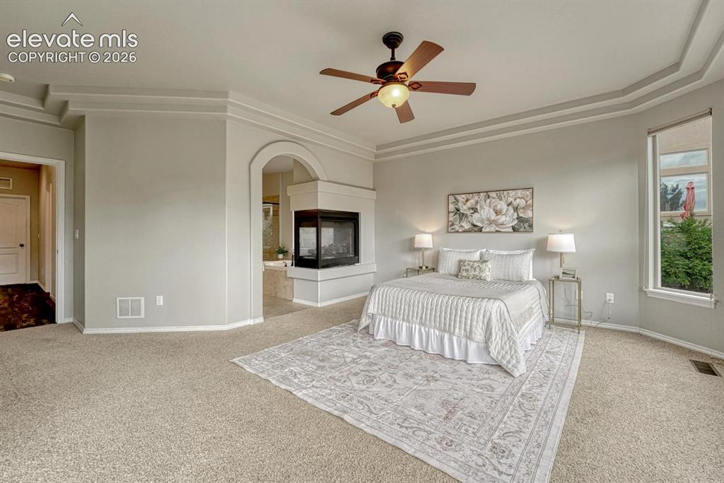 Image 9 of 50: Relax in your private main level Primary Retreat with neutral carpet, a tra