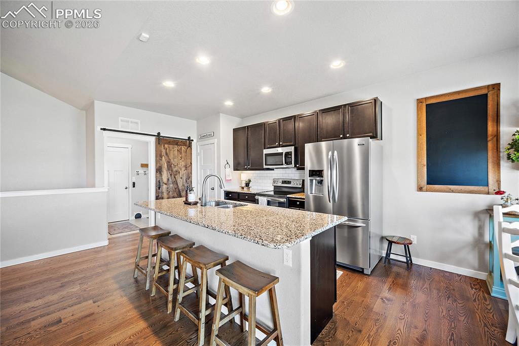 Image 12 of 44: Custom barn door separates the main level laundry and mudroom off the garag