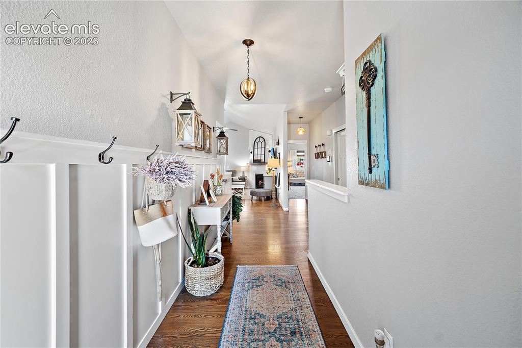 Image 31 of 44: Front entry with beautiful hardwood flooring, wainscoting and vaulted ceili