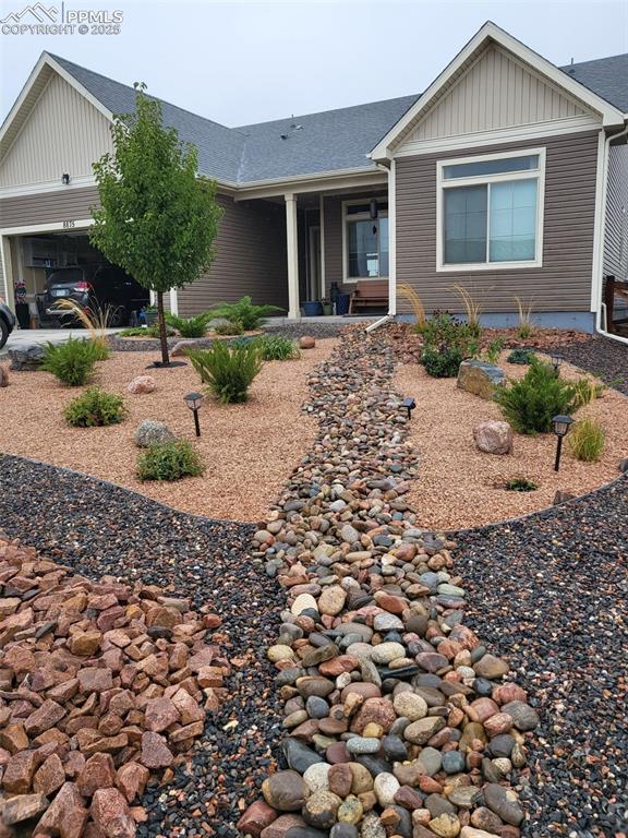 Image 11 of 50: Ranch-style house featuring board and batten siding and roof with shingles