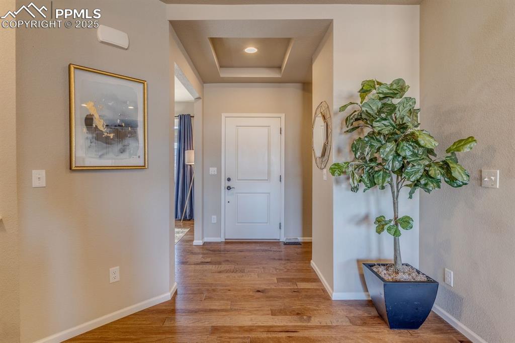 Image 12 of 50: Hall with light wood-style flooring and a raised ceiling