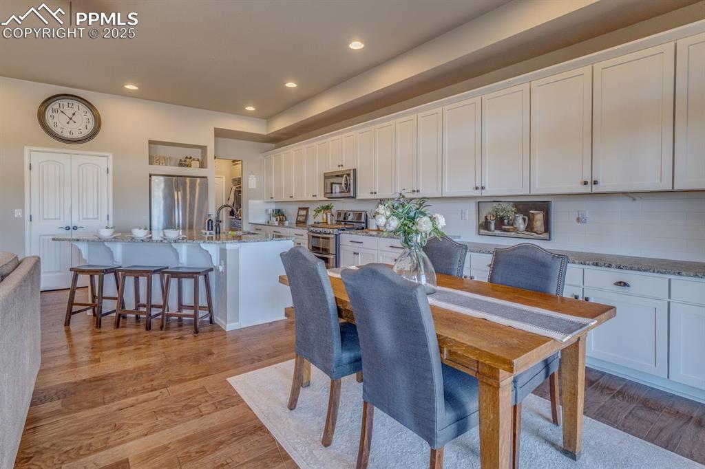 Image 3 of 50: Dining room with light wood-style floors and recessed lighting