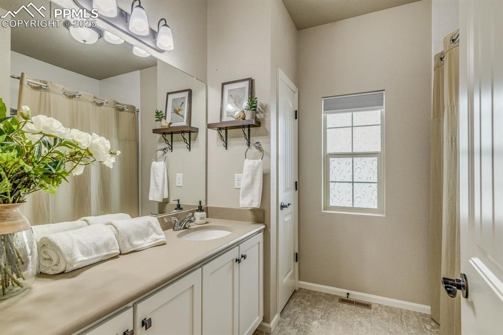 Image 33 of 50: Bathroom featuring vanity and curtained shower