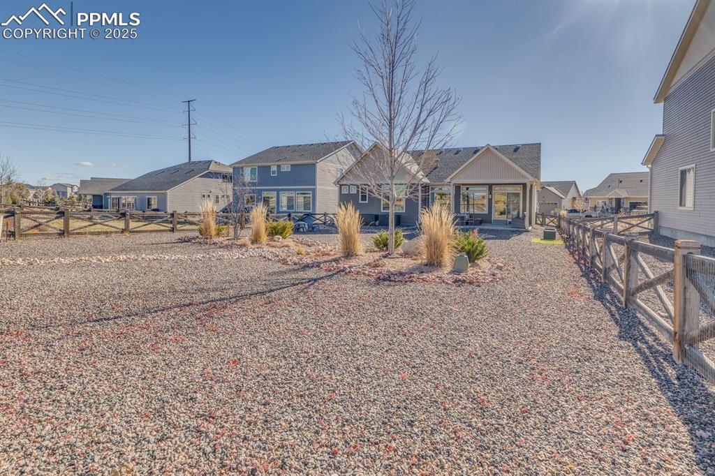 Image 42 of 50: View of front facade with a fenced backyard, a residential view, and a pati
