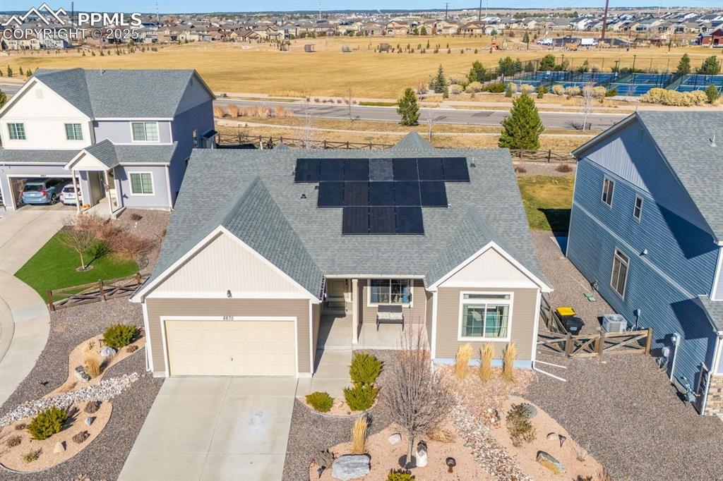 Image 47 of 50: View of front of house with solar panels, roof with shingles, concrete driv