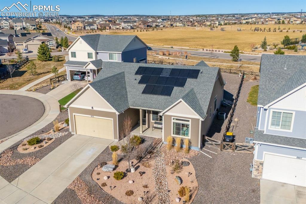 Image 49 of 50: Drone shot of the front of the house with open space behind.