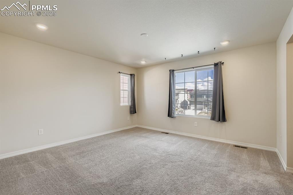 Image 11 of 26: Unfurnished room with light colored carpet, plenty of natural light, and re