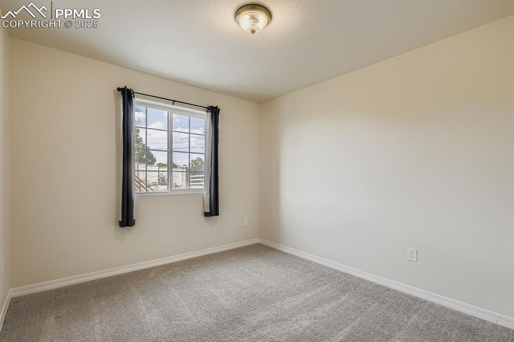 Image 16 of 26: Carpeted empty room featuring baseboards