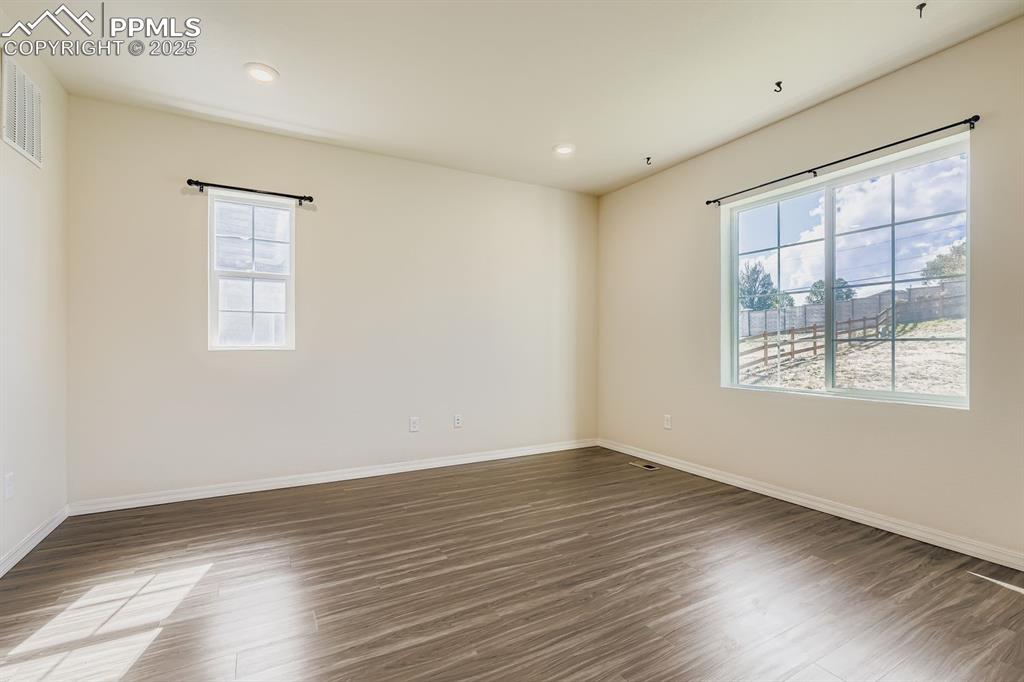 Image 20 of 26: Spare room with wood finished floors and recessed lighting