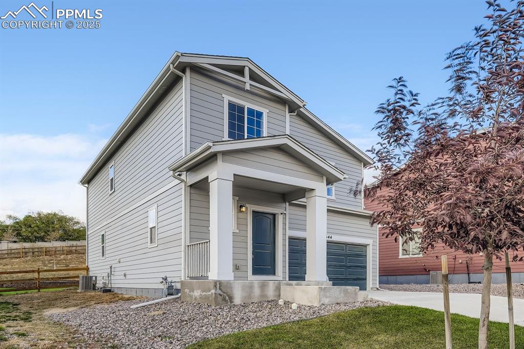 Image 21 of 26: View of front of home with a garage and concrete driveway
