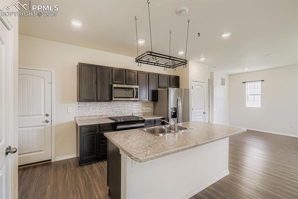 Image 26 of 26: Kitchen featuring tasteful backsplash, light countertops, stainless steel a