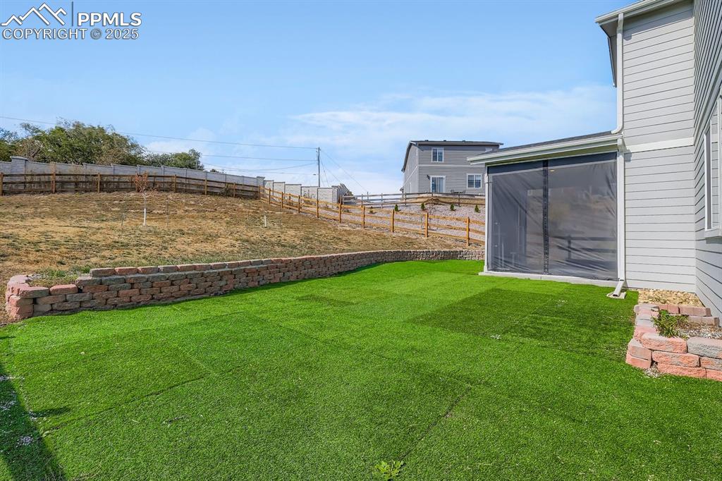 Image 3 of 26: Fenced backyard with a sunroom