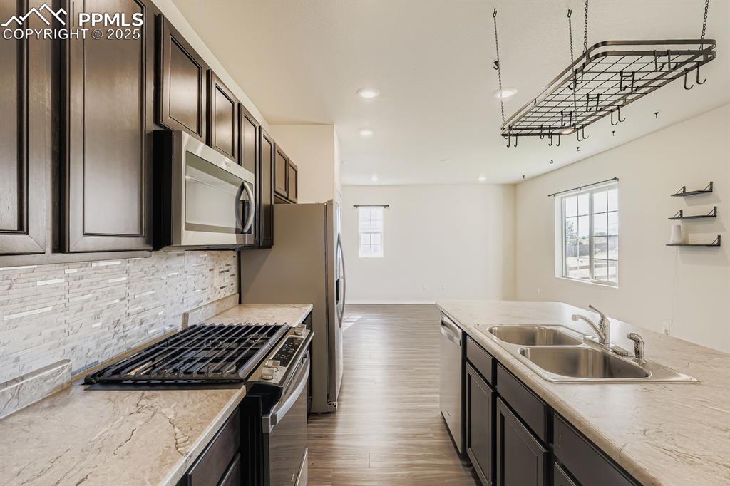 Image 4 of 26: Kitchen with stainless steel appliances, light countertops, recessed lighti