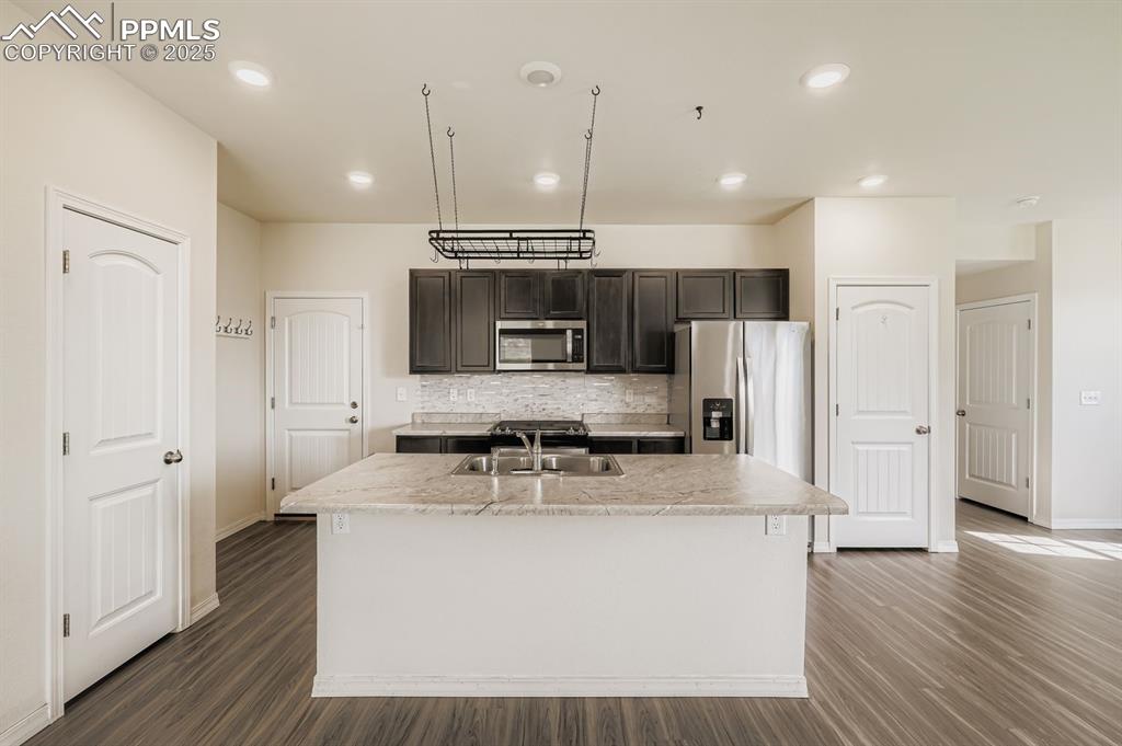 Image 5 of 26: Kitchen featuring decorative backsplash, light countertops, dark wood-style