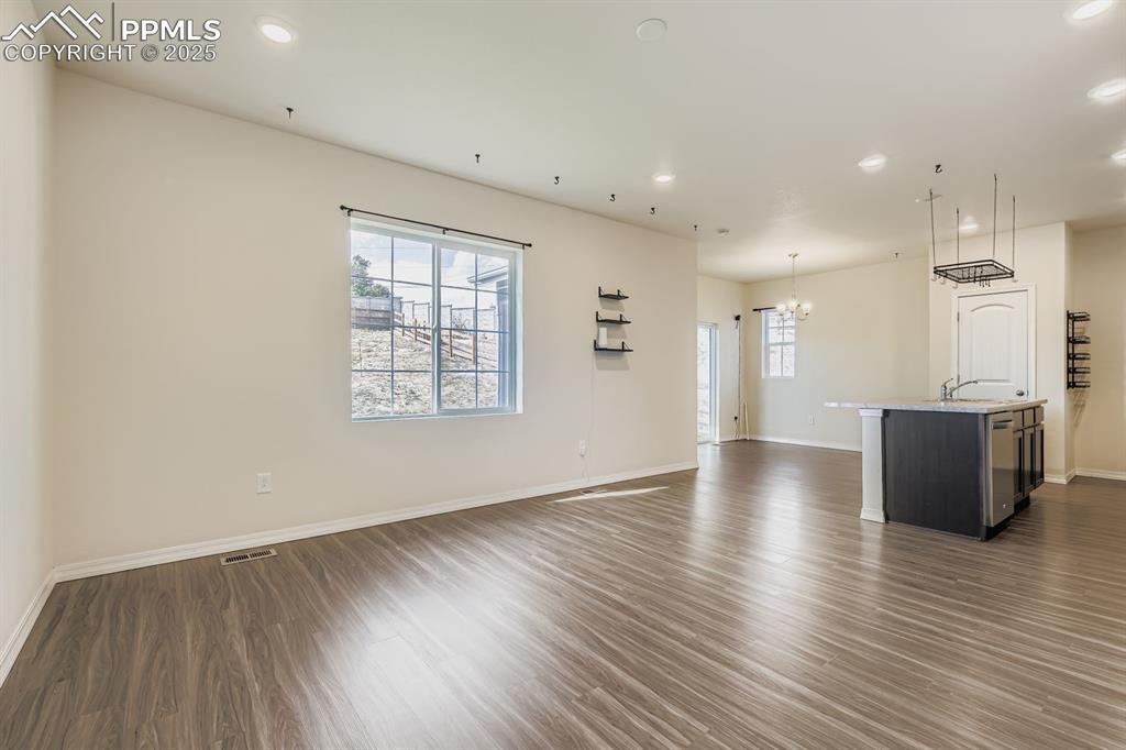 Image 6 of 26: Unfurnished living room with recessed lighting, dark wood finished floors,