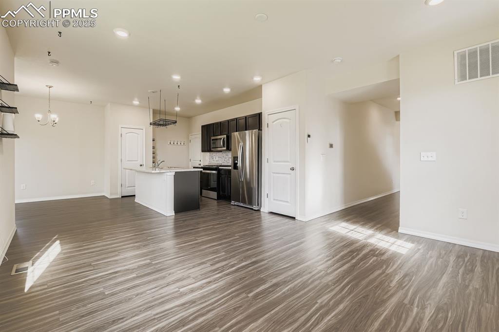 Image 7 of 26: Unfurnished living room featuring dark wood-type flooring, recessed lightin