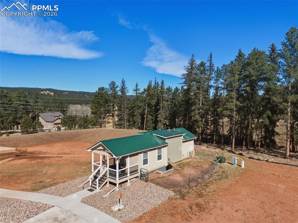 Image 2 of 23: Corner lot with open space to the left and golf course behind the trees off