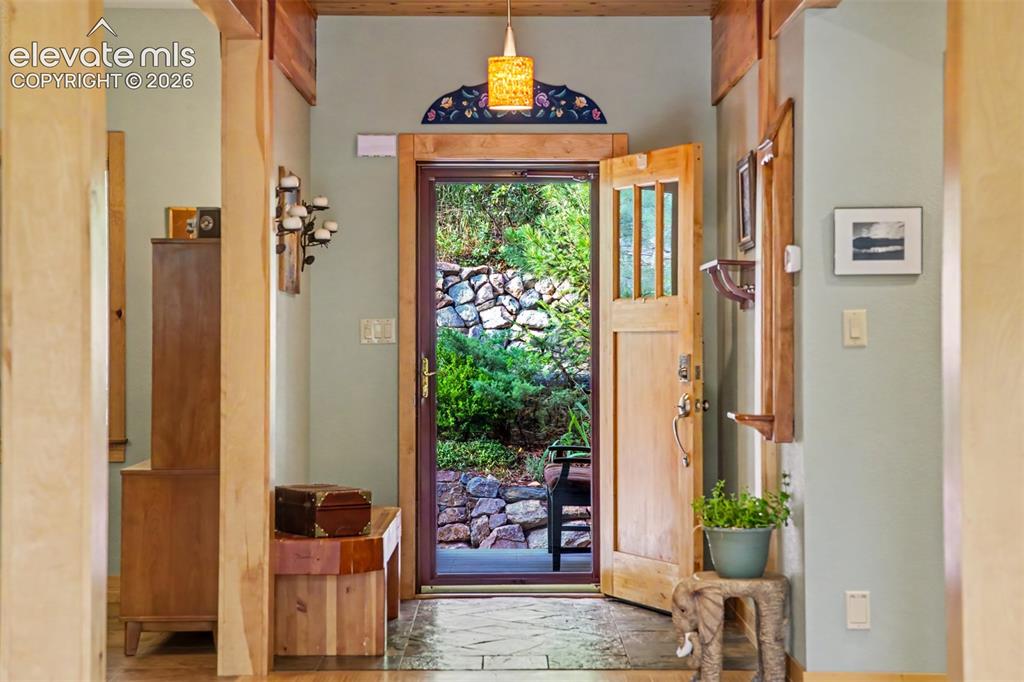 Image 10 of 50: The welcoming foyer introduces handcrafted alder millwork and warm natural 