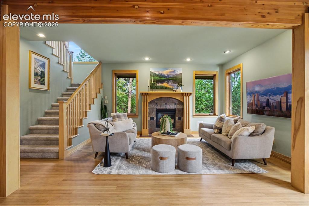 Image 15 of 50: The living room centers around a gas fireplace framed with warm tile and ex