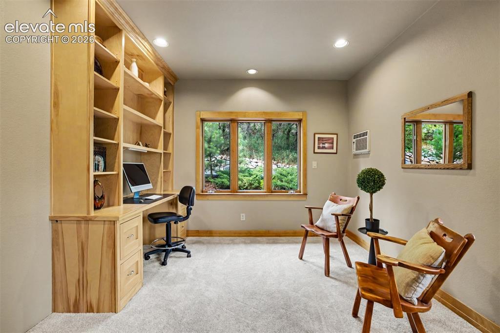 Image 19 of 50: Custom built-ins create an ideal home office with views of the surrounding 
