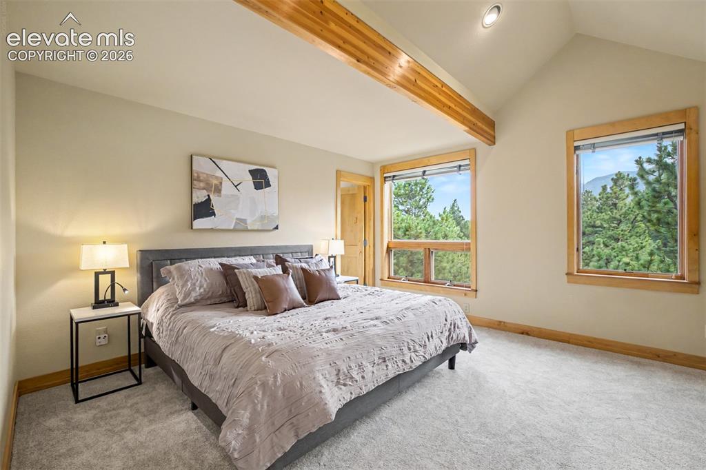 Image 20 of 50: The primary bedroom enjoys mountain views and abundant natural light.