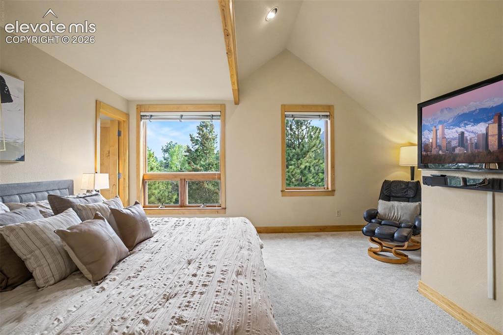 Image 22 of 50: Large windows fill the primary bedroom with natural light and views of the 