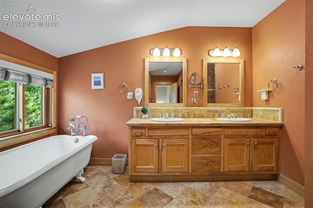 Image 23 of 50: The primary bathroom features dual vanities, a private shower and a soaking