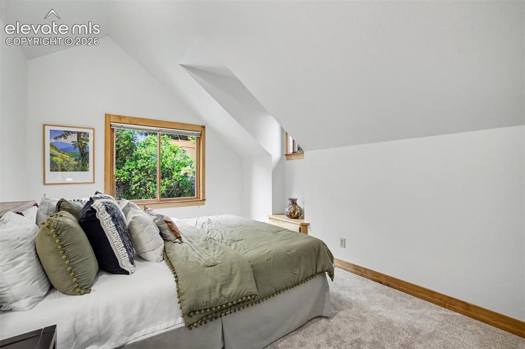 Image 26 of 50: One of 2 identical upstairs bedrooms featuring custom glass transoms, gener