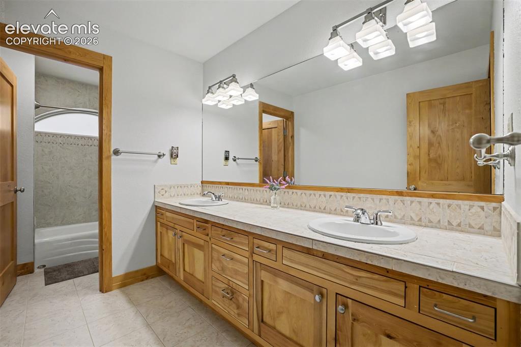 Image 27 of 50: The shared upstairs bathroom features a dual-sink vanity with a separate ro