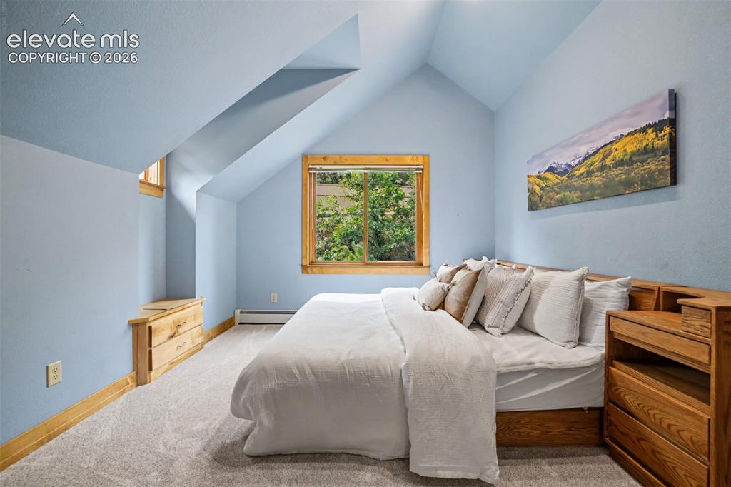 Image 28 of 50: The second of 2 identical upstairs bedrooms features custom glass transoms,